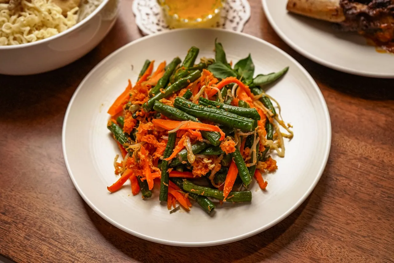 Colorful Indonesian vegetable stir fry with carrots and green beans on a plate.