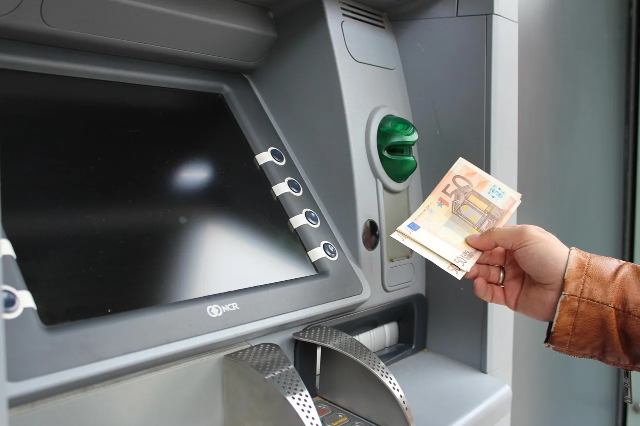 A person withdrawing cash from an ATM.