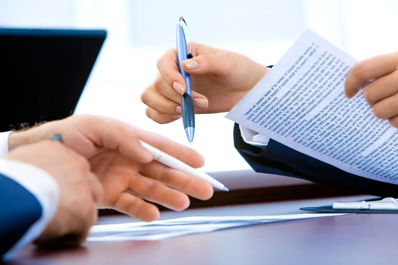 Stock photo related to laptop, office, hand, writing for the topic of open enrollment benefits form